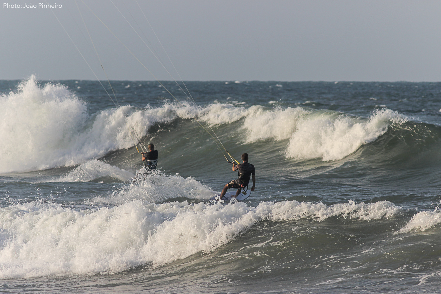 2 kitesurfeurs au mileu des vagues