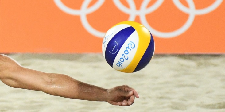 gros plan sur un bras et un ballon de beach volley au JO 2016 de Rio de Janeiro.