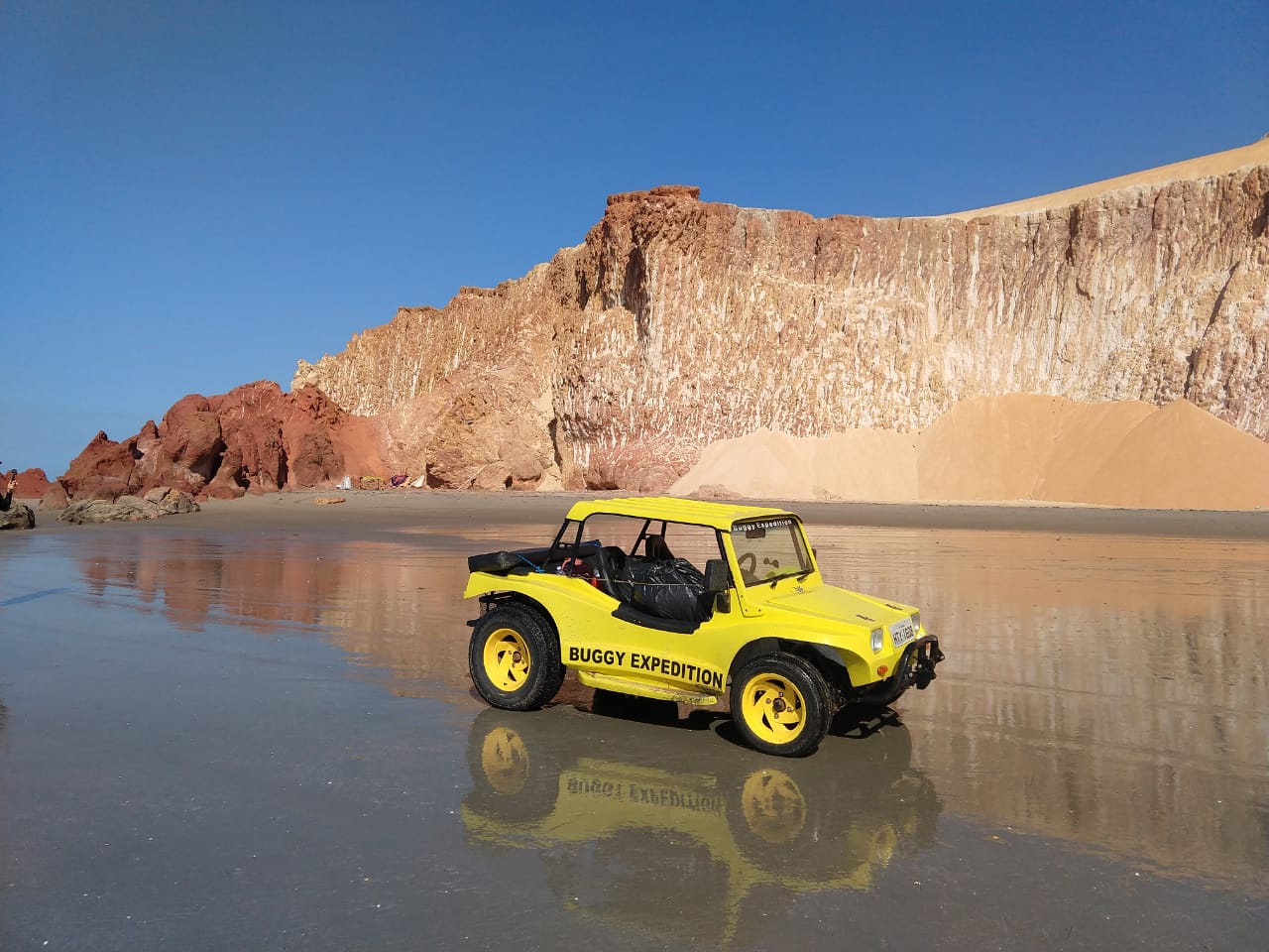 un buggy sur la plage au pied de la falaise dans le Nordeste du Brésil.