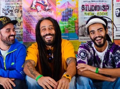 Membre du groupe Veja Luz souriants et accroupis devant un mur.