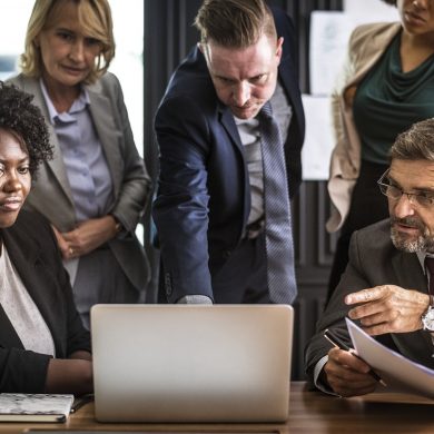 5 personnes autour d'un ordinateur portable pour prendre une décision de travail.