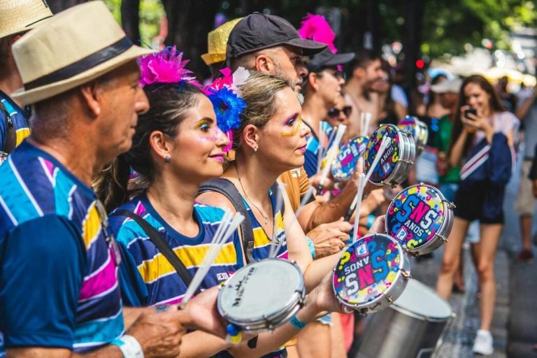 Musiciens en tenues colorées et chapeaux jouant du tambourin et du pandeiro dans la foule lors d'un carnaval de rue durant un voyage festif au Brésil.