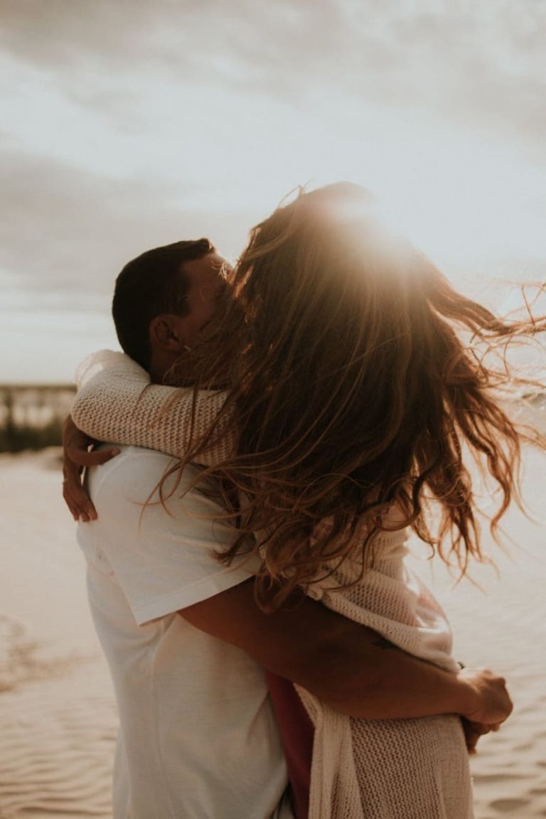 Couple enlacé sur une plage au coucher du soleil lors d'un voyage de noces au Brésil.